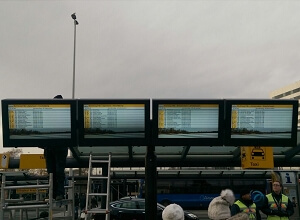 Quattro involucri per digital signage da esterno per aeroporti in formato verticale presso una fermata dell'autobus